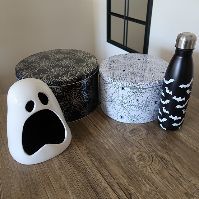 Halloween spiderweb-patterned cake tins, a bat-patterned water bottle and ghost-shaped candy bowl