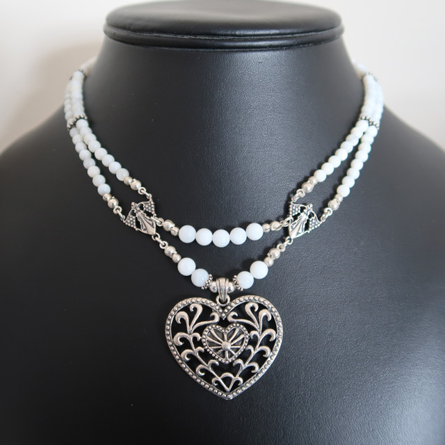 A white mother-of-pearl beaded necklace with a filigree heart pendant