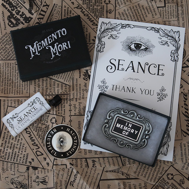 A pin badge reproduction of a mourning brooch and a perfume sample by Seance
